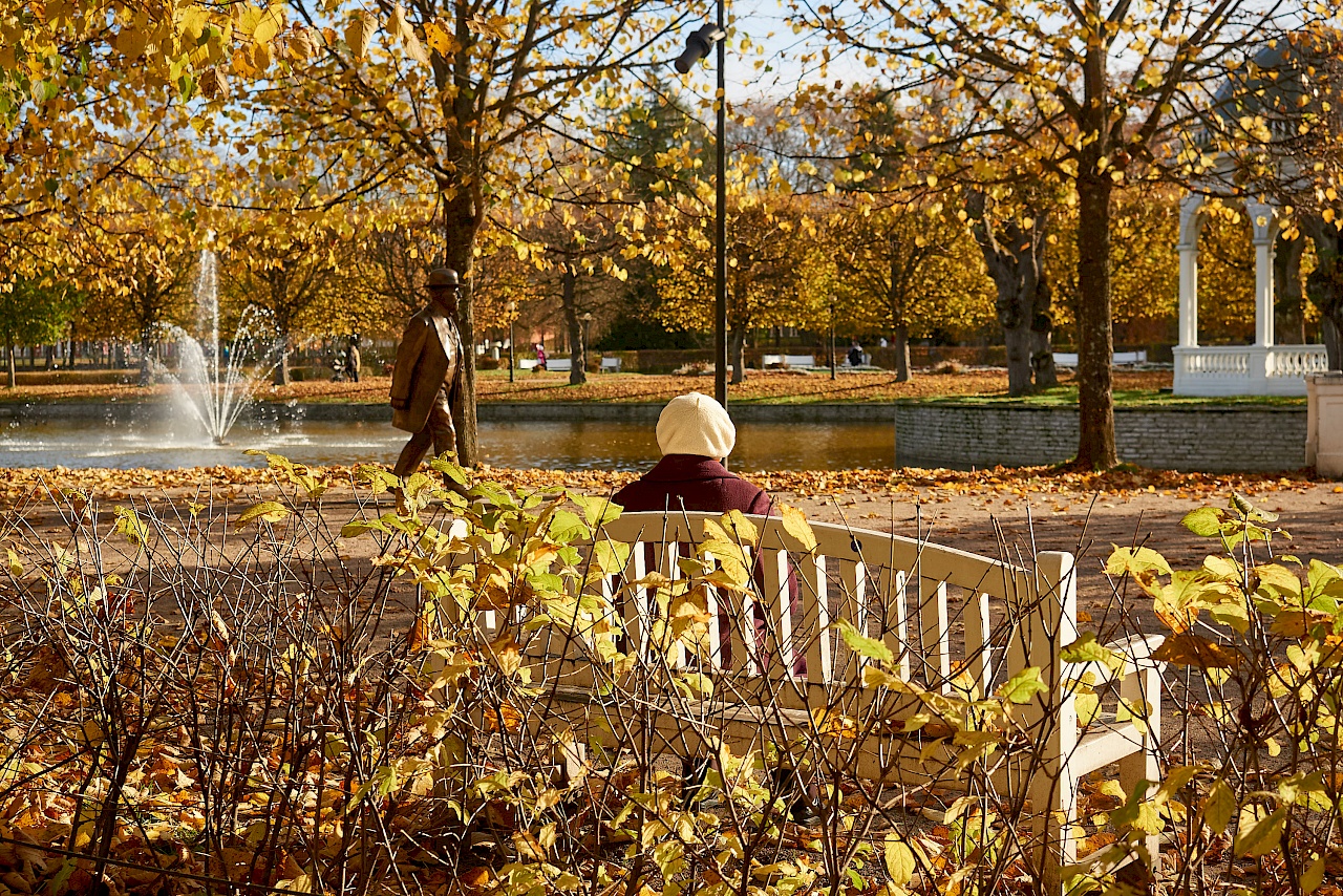 Ältere Dame sitzt auf einer Bank im Kadriorg Park