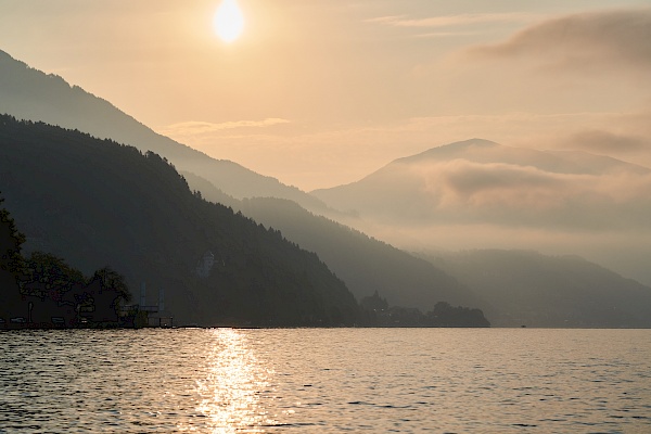 Mit dem Ruderboot bei Sonnenaufgang auf dem Millstättter See - Blick auf die Berge.